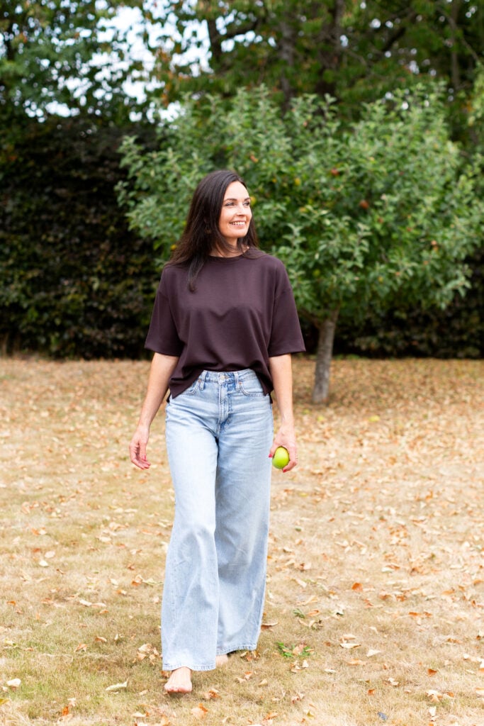 Ruth walking in nature with a small tree in the background